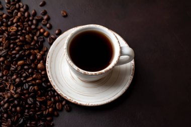 Kahve çekirdekleri ile siyah taş arka planda kahve taze fincan 