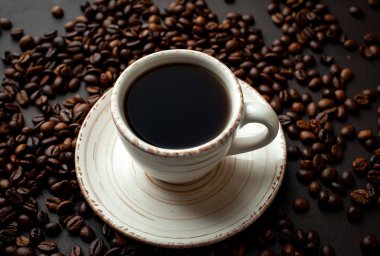 Kahve çekirdekleri ile siyah taş arka planda kahve taze fincan 