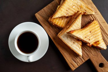 Ahşap Doğrama tahtasında fincan kahve ile servis edilen ızgara sandviçler