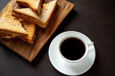 Ahşap Doğrama tahtasında fincan kahve ile servis edilen ızgara sandviçler