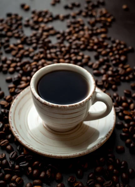 Fresh cup of coffee on black stone background with coffee beans