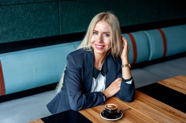 Şık sarışın kadın mavi kafe iç kahve fincan içme 