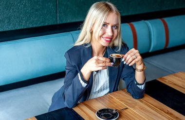 Şık sarışın kadın mavi kafe iç kahve fincan içme 