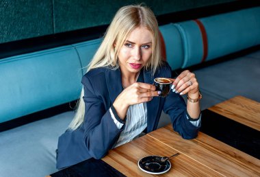 Şık sarışın kadın mavi kafe iç kahve fincan içme 