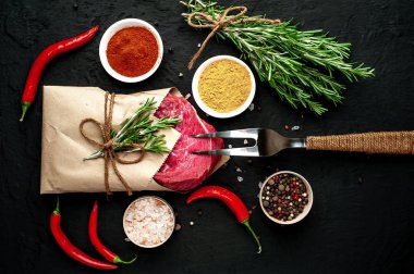 Siyah taş arka plan üzerinde baharat ile Çiğ taze biftek