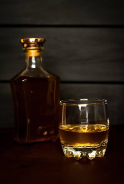 Siyah arka planda buz küpleri ve viski şişesi ile viski Bir bardak 