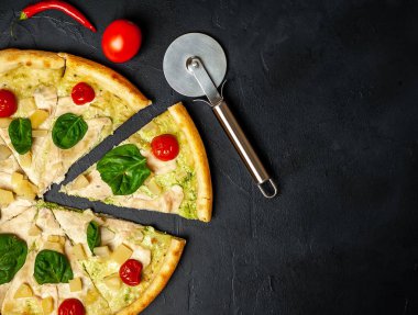 siyah taş arka plan üzerinde kiraz domates ve taze ıspanak yaprakları ile pizza