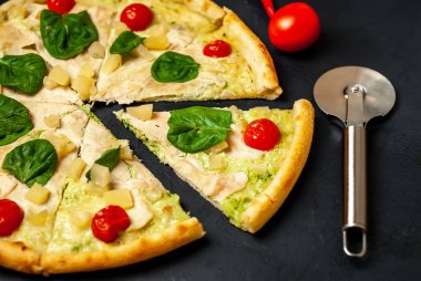 siyah taş arka plan üzerinde kiraz domates ve taze ıspanak yaprakları ile pizza