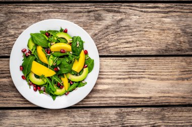 Arugula, ıspanak, dilimlenmiş mango ve avokado, nar ve ayçiçeği tohumu ile taze vegan salata