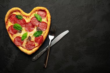 salam ve taze fesleğen yaprakları taş siyah arka plan peynir kalp pizza 