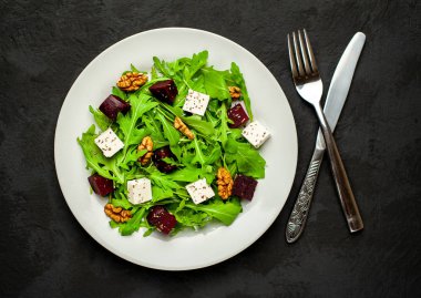 Arugula ve ıspanak ile taze salata, dilimlenmiş pancar, beyaz peynir ve ceviz