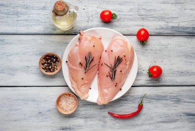 Çiğ tavuk göğüsleri baharat ve biberiye ile marine domates ve zeytinyağı ile servis 