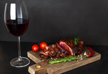 ahşap tahta üzerinde orta nadir sığır biftek kırmızı şarap cam ile servis
