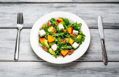 Yeşillik, hurma ve avokado dilimleri, ceviz ve beyaz peynir ile taze vejetaryen salata