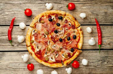 Ahşap arka plan üzerinde mantar, domates, zeytin ve jambon ile taze ev yapımı pizza