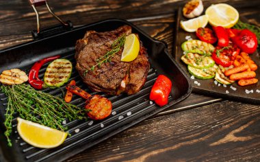 Izgara tavada biberiye ve sebze ile Taze ızgara domuz biftek 