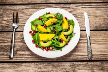 Arugula, ıspanak, dilimlenmiş mango ve avokado, nar ve ayçiçeği tohumu ile taze vegan salata