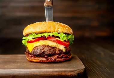 Ahşap arka planda bıçak yapışabilir taze ev yapımı Burger