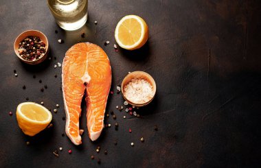 Siyah taş arka plan üzerinde baharat ve limon ile taze çiğ somon biftek
