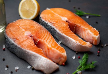 Siyah taş arka plan üzerinde baharat ve limon ile taze çiğ somon biftek