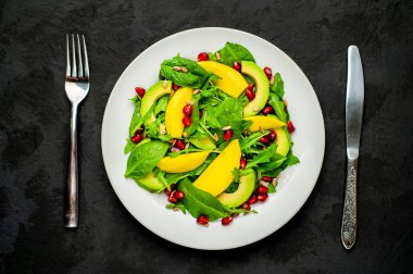 Arugula, ıspanak, dilimlenmiş mango ve avokado, nar ve ayçiçeği tohumu ile taze vegan salata