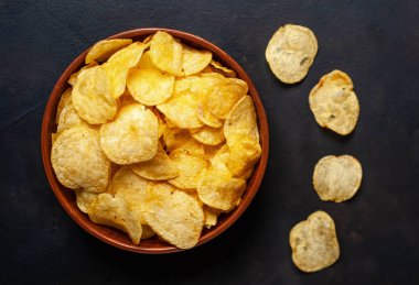 Siyah taş arka plan üzerinde gevrek tuzlu patates cips