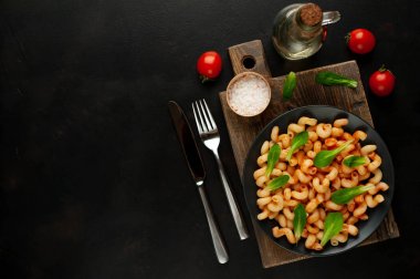 taş siyah arka plan üzerinde ahşap doğrama tahtası üzerinde domates soslu makarna