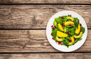 Arugula, ıspanak, dilimlenmiş mango ve avokado, nar ve ayçiçeği tohumu ile taze vegan salata