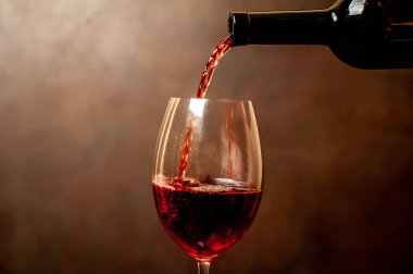 Koyu arka planda cam dökülen kırmızı şarap yakın görünümü 