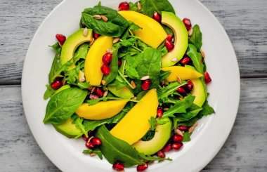 Arugula, ıspanak, dilimlenmiş mango ve avokado, nar ve ayçiçeği tohumu ile taze vegan salata