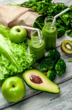 Gri arka planda sebze ve meyve ile Taze yeşil smoothie