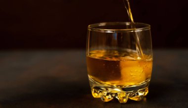 Siyah arka planda bir bardak buz viskisi