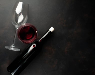Siyah arka planda kırmızı şarap ve şarap şişesi bardak