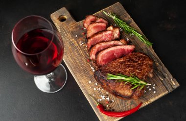 ahşap tahta üzerinde orta nadir sığır biftek kırmızı şarap cam ile servis
