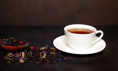 siyah arka plan üzerinde çiçek demlemek yığını ile taze çay fincan