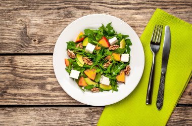 Yeşillik, hurma ve avokado dilimleri, ceviz ve beyaz peynir ile taze vejetaryen salata