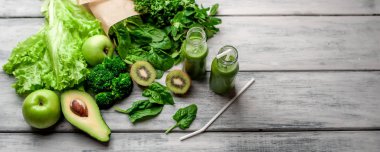 Gri arka planda sebze ve meyve ile Taze yeşil smoothie