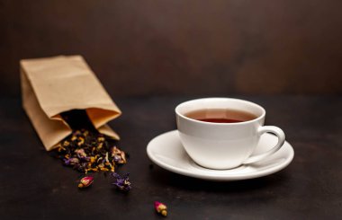 siyah arka plan üzerinde çiçek demlemek dolu kağıt torba ile taze çay fincan