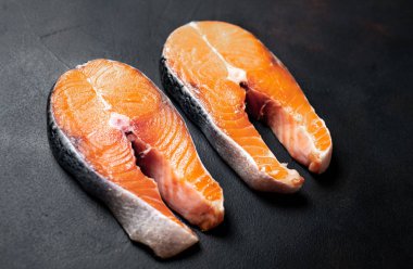 Siyah taş arka plan üzerinde çift çiğ somon biftek