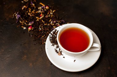 siyah arka plan üzerinde çiçek demlemek yığını ile taze çay fincan