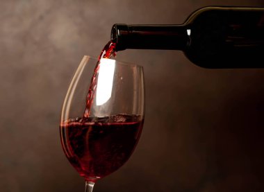 Koyu arka planda cam dökülen kırmızı şarap yakın görünümü 