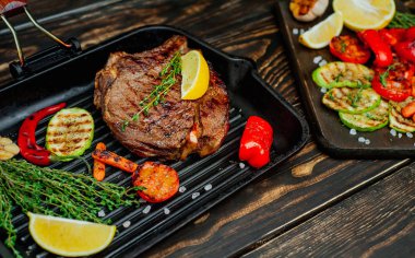 Izgara tavada biberiye ve sebze ile Taze ızgara domuz biftek 