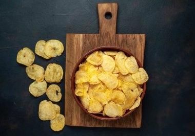 Siyah taş arka plan üzerinde gevrek tuzlu patates cips