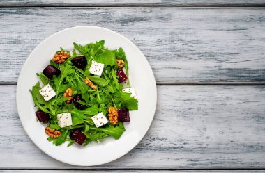 Arugula ve ıspanak ile taze salata, dilimlenmiş pancar, beyaz peynir ve ceviz