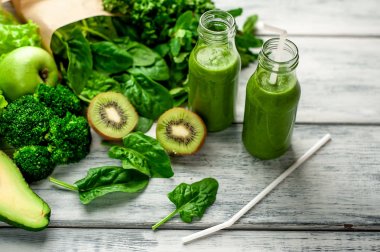 Gri arka planda sebze ve meyve ile Taze yeşil smoothie