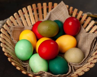 Siyah taş arka planda renkli Paskalya yumurtaları ile sepet yakın görünümü