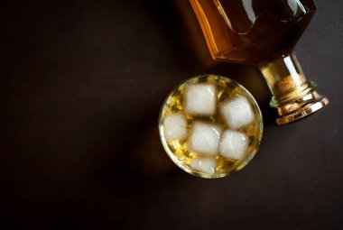 Siyah arka planda buz küpleri ve viski şişesi ile viski Bir bardak 