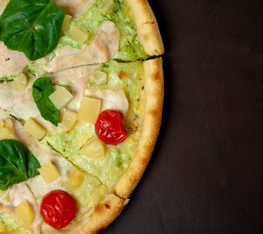 siyah taş arka plan üzerinde kiraz domates ve taze ıspanak yaprakları ile pizza