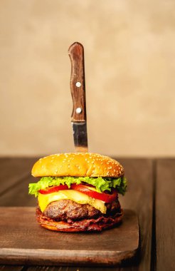 Ahşap arka planda bıçak yapışabilir taze ev yapımı Burger