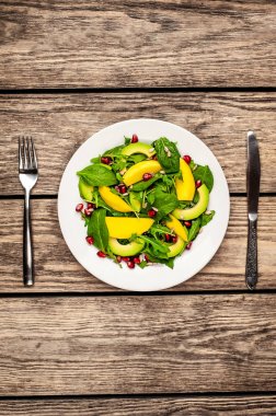 Arugula, ıspanak, dilimlenmiş mango ve avokado, nar ve ayçiçeği tohumu ile taze vegan salata